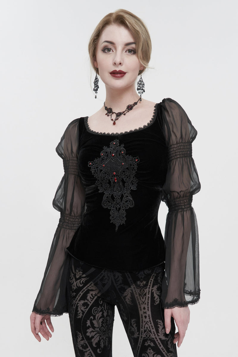 Woman wearing a black lace top with sheer sleeves on a white background