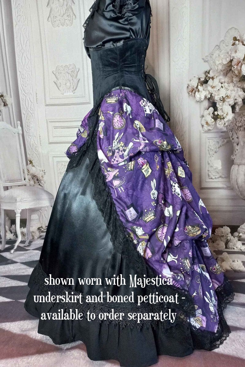 side view of the victorian bustle  high low skirt made from custom designed purple alice in wonderland fabric worn with a boned petticoat underneath