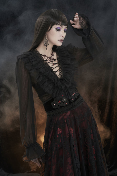 Person wearing a black, lace-up pirate top with sheer sleeves and a dark skirt against a smoky background