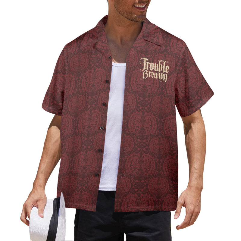 Man wearing a patterned red shirt with 'Trouble Brewing' text on a white background
