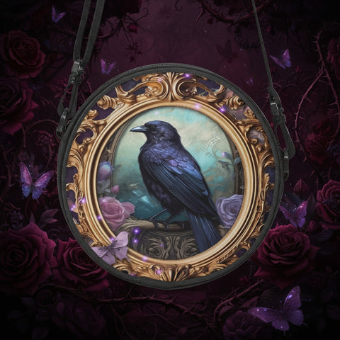glossy black raven perched inside a gold rococo gilt frame features as the art work on this 23cm diameter round canvas cross body bag