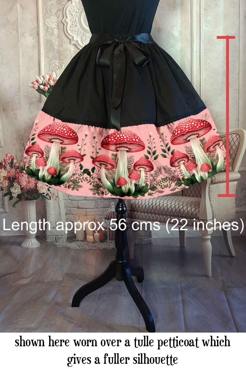 red toadstools on a vintage pink background on a 50s shaped mid length cottagecore, mushroomcore skirt with overlaid text showing skirt length of 56cms
