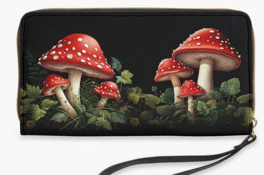red and white toadstools amongst green leaves on a cottagecore vegan wallet