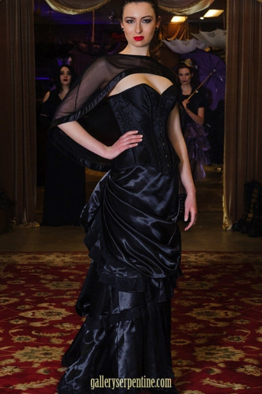 over the bust ebony turn of the century corset on a model with a victorian skirt and mesh cape top