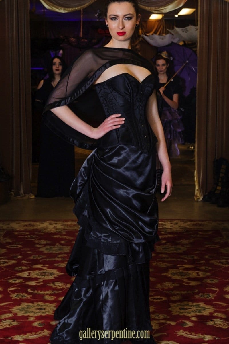 over the bust ebony turn of the century corset on a model with a victorian skirt and mesh cape top
