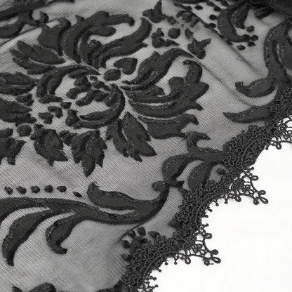 detail image of the fabric showing the ornate lace trim on the edge and the velvet floral swirls of the mesh