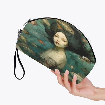 woman holding up the oil painting print of a mermaid surrounded by fish on a handy makeup purse with zip at Gallery Serpentine