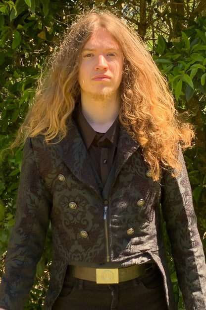 Person with long hair wearing a dark patterned coat outdoors