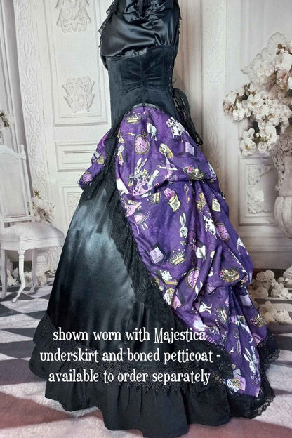 side view of the victorian bustle  high low skirt made from custom designed purple alice in wonderland fabric worn with a boned petticoat underneath