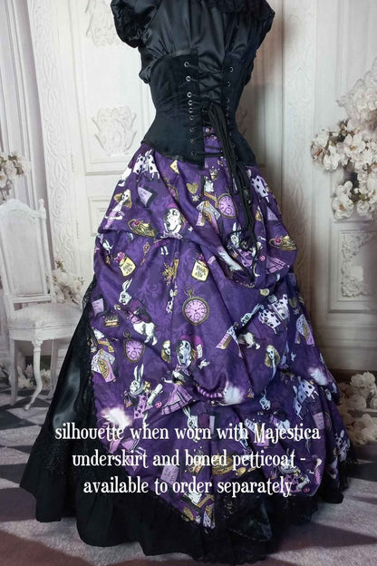 back side view of the victorian bustle  high low skirt made from custom designed purple alice in wonderland fabric worn with a boned petticoat underneath