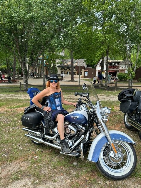 Tamara Pakulski wearing the Tardis Corset from Gallery Serpentine on her blue Harley bike to the Georgia Renaissance Faire 2024