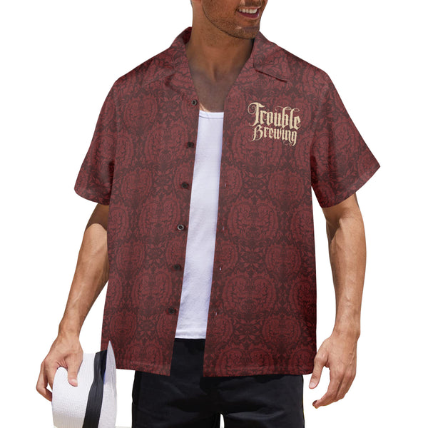 Man wearing a patterned red shirt with 'Trouble Brewing' text on a white background