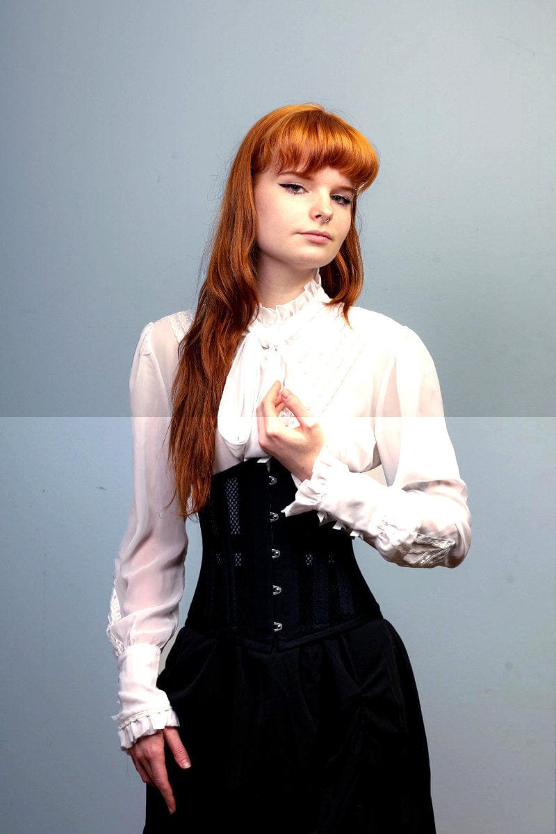 close up on the black cotton and mesh doubleboned under bust corset for waist control and posture at Gallery Serpentine worn by a red headed  corporate woman