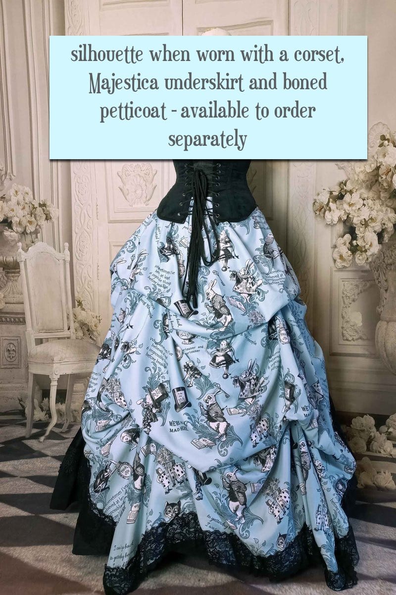 blue Alice in Wonderland victorian high low bustle skirt printed with Alice quotes, the white rabbit, Alice and many of the characters, trimmed in black braid, shown here with a fuller profile due to a boned petticoat underneath