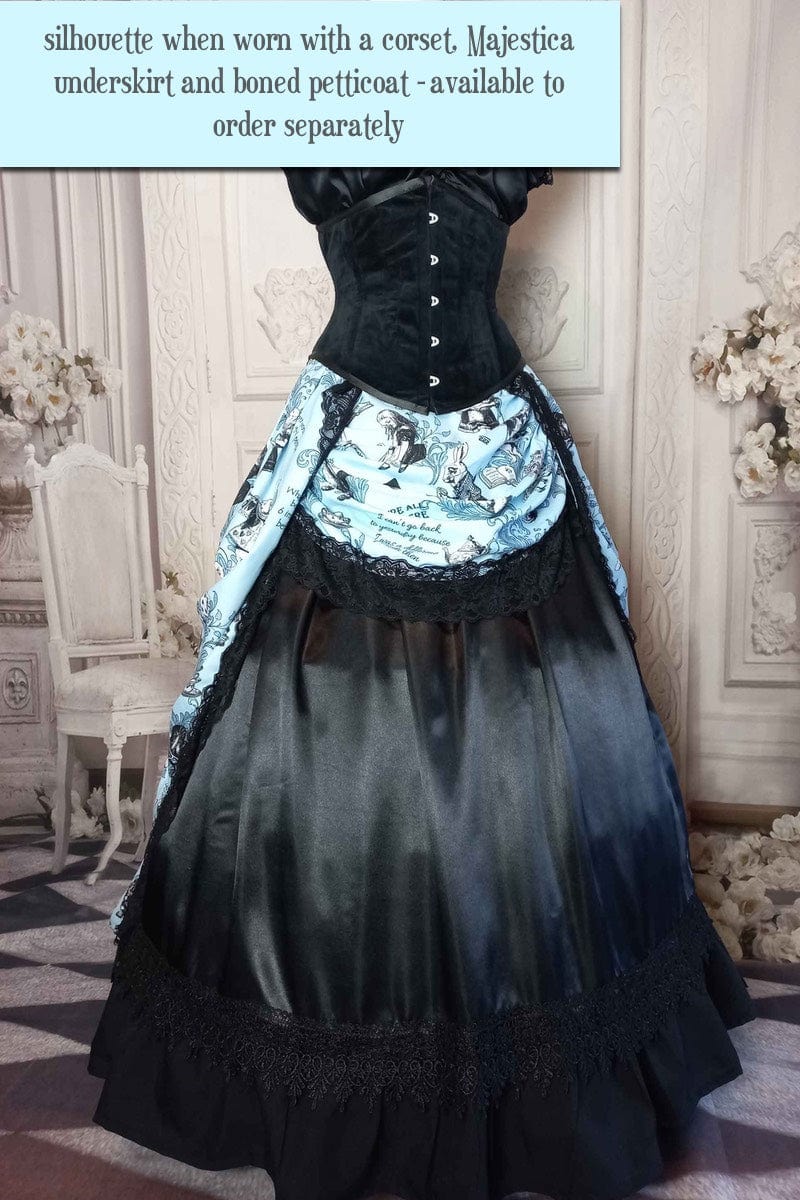 blue Alice in Wonderland victorian high low bustle skirt printed with Alice quotes, the white rabbit, Alice and many of the characters, trimmed in black braid, shown here with a fuller profile due to a boned petticoat underneath 1