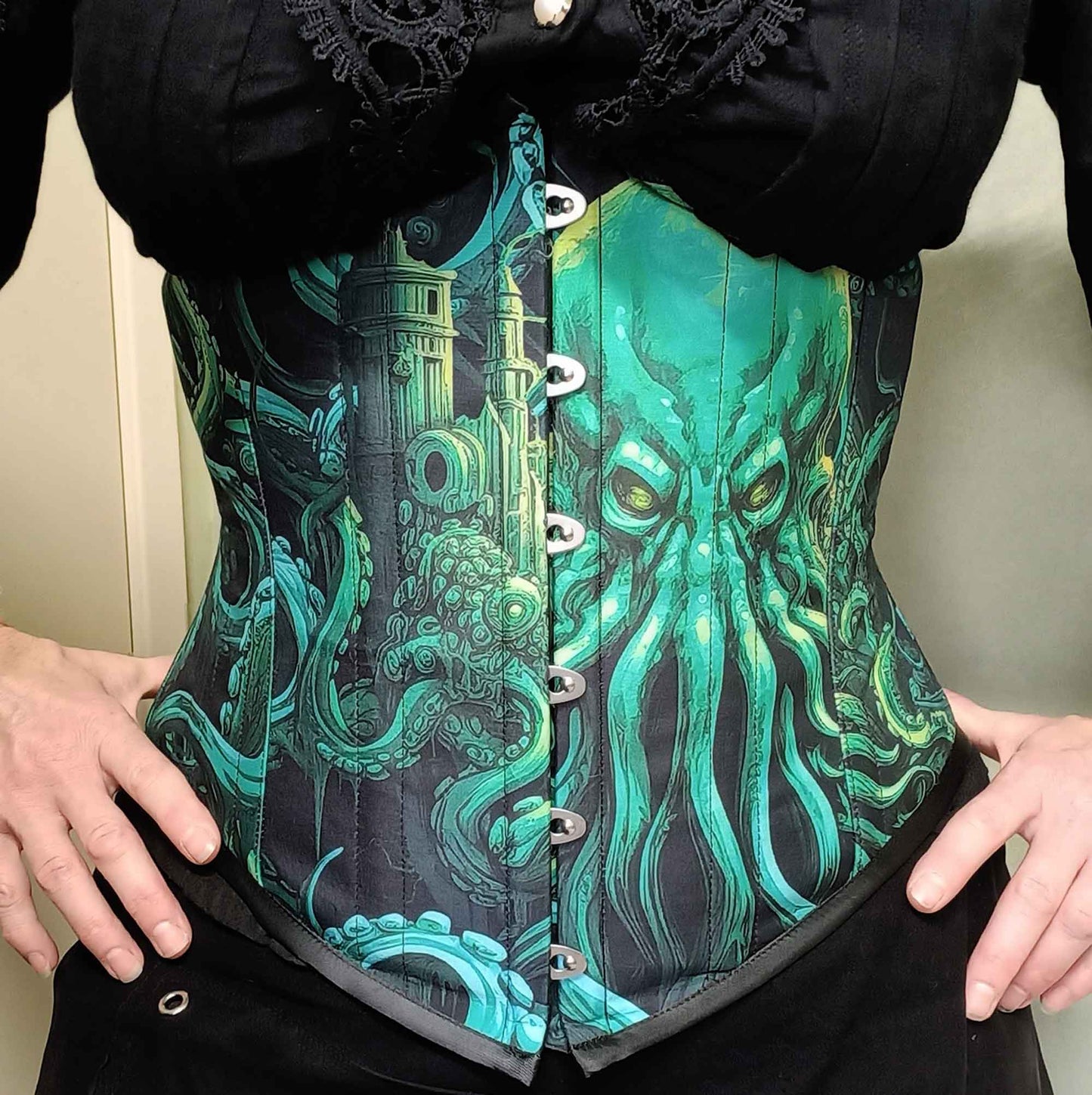 front view of the Call of Cthulhu under bust corset in vibrant and dark greens and blacks featuring the Lovecraft sea monster on an Australian made custom sized corset at Gallery Serpentine