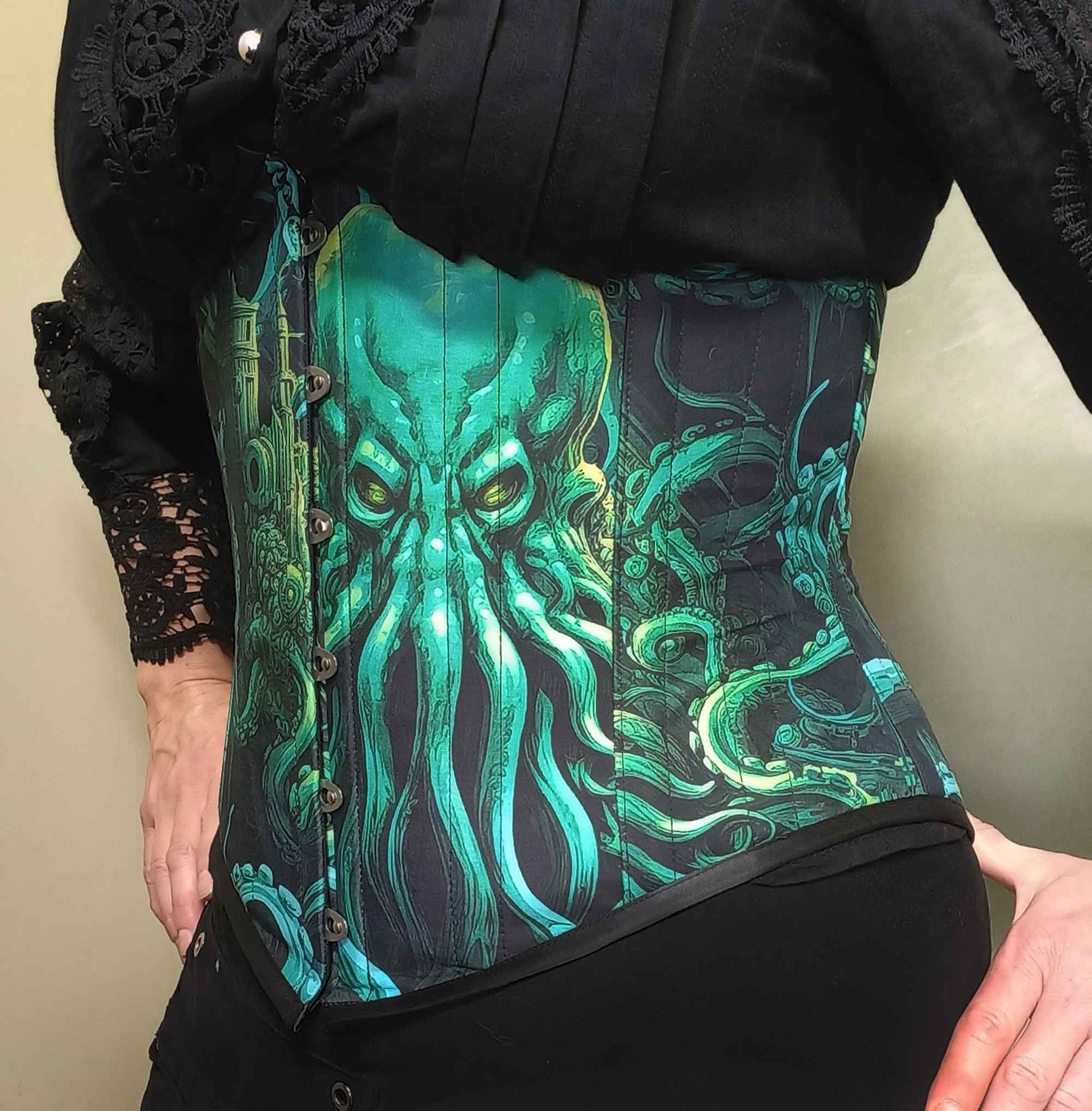 Call of Cthulhu under bust corset in vibrant and dark greens and blacks featuring the Lovecraft sea monster on an Australian made custom sized corset at Gallery Serpentine