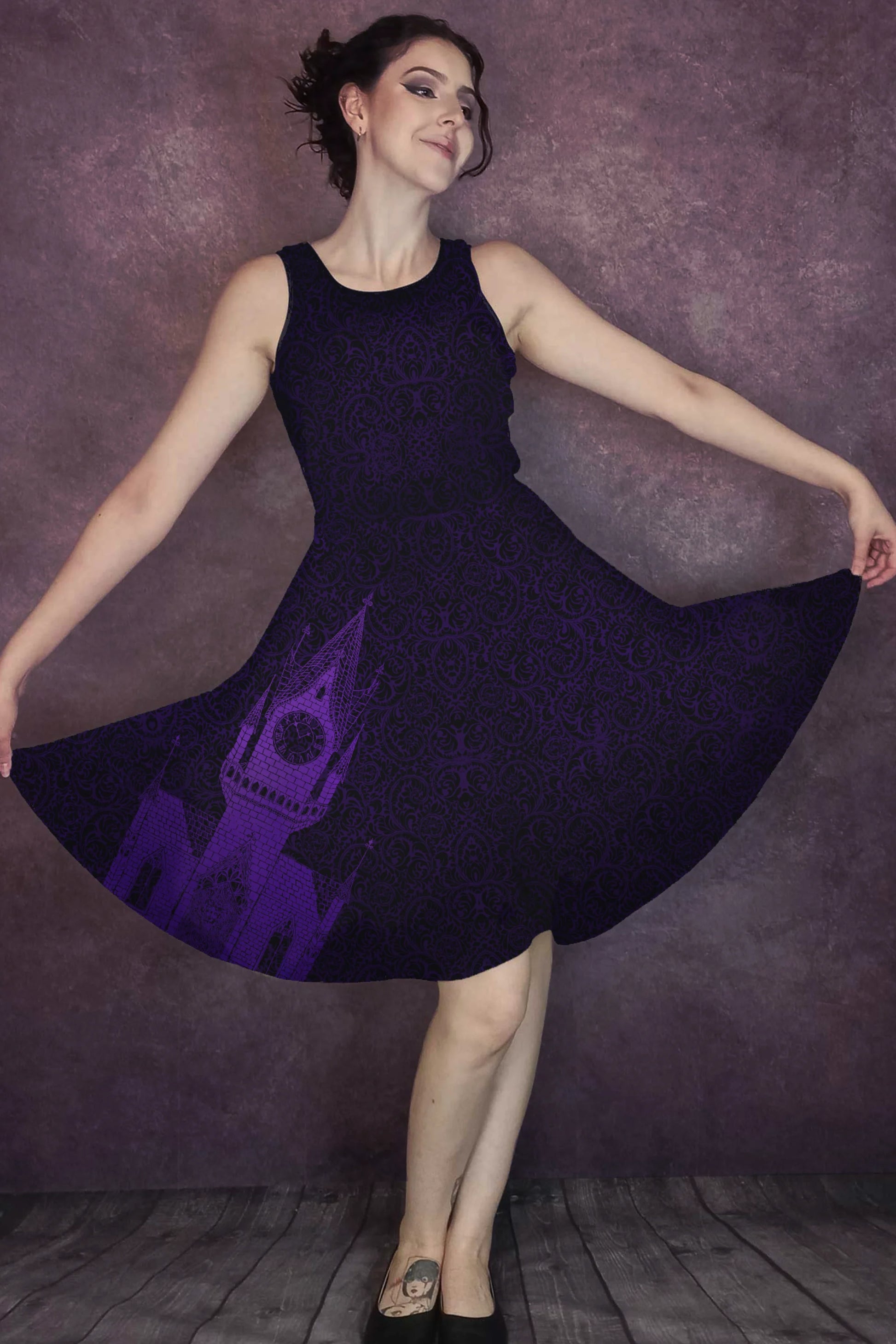 Woman wearing a dark purple dress with a purple clocktower design, standing against a purple background.