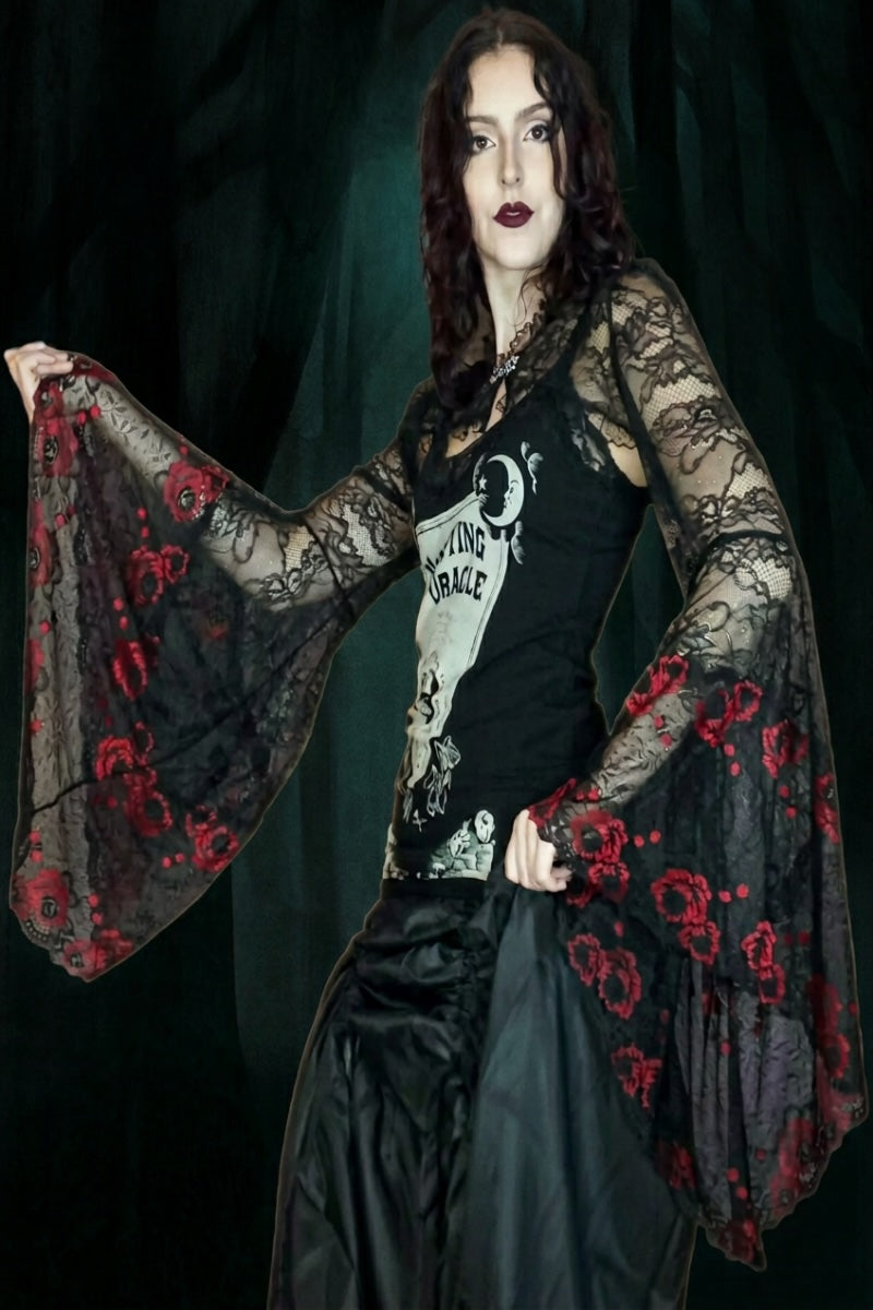 gothic model wearing a black lace bolero with embroidered red roses on the extreme medieval angel sleeves