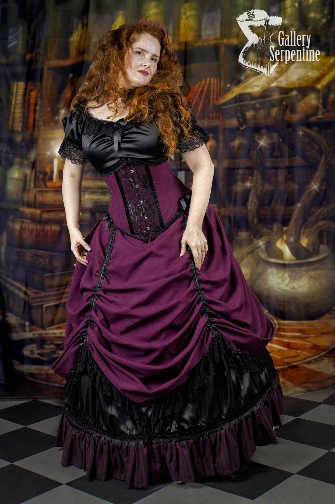 model at Hogwarts library wearing the model showing the matching under bust victorian corset that goes with the Burgundy Beauty skirt set