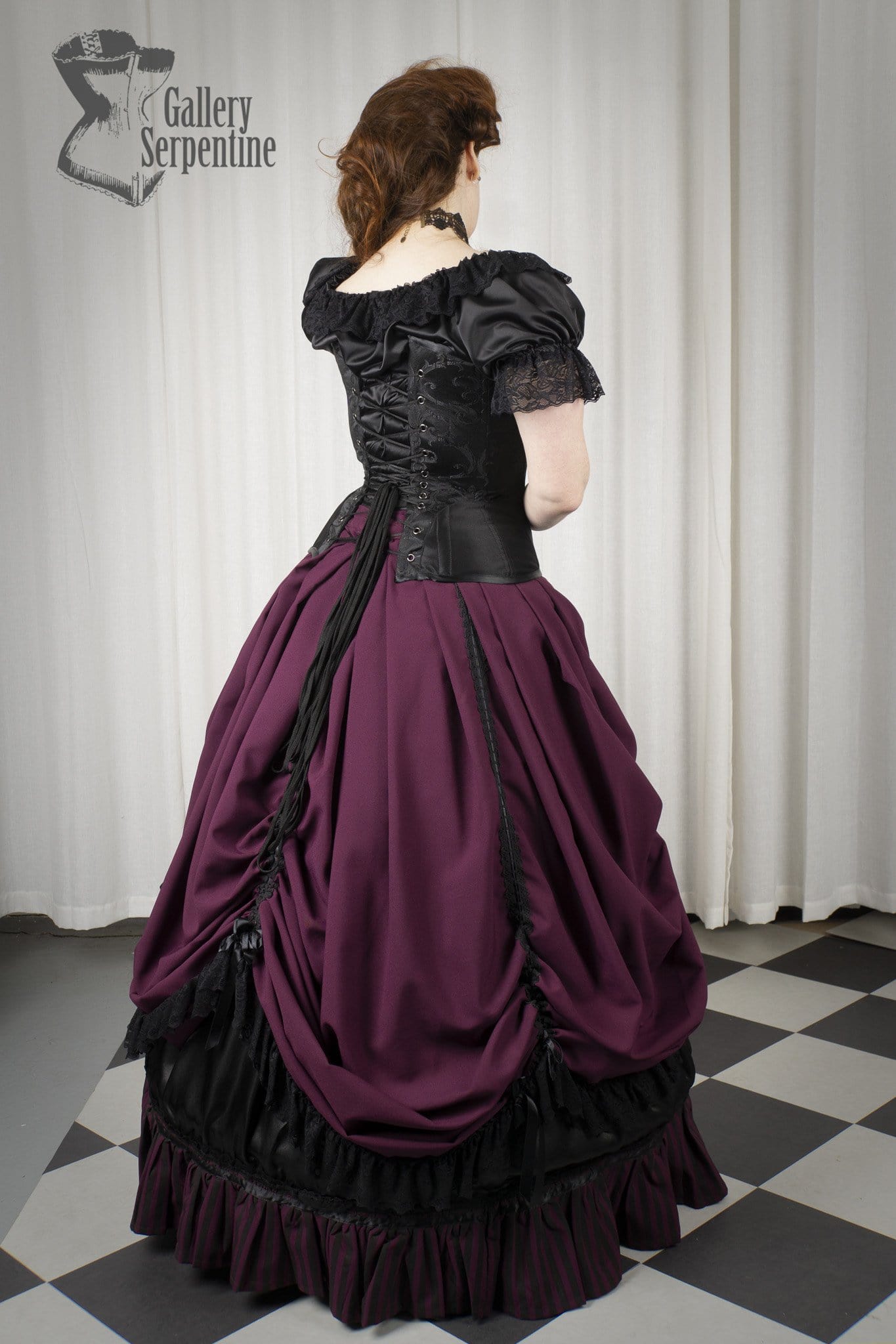 back view of the new front lacing black turn of the century corset worn with a romantic burgundy victorian era skirt set