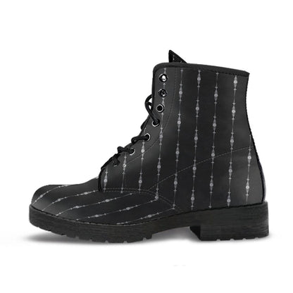 close up side view of the gothic pinstripe pattern on a pair of black vegan leather boots at Gallery Serpentine