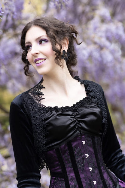 smiling victorian model wearing Gallery Serpentine corset bustle gown in purple and black