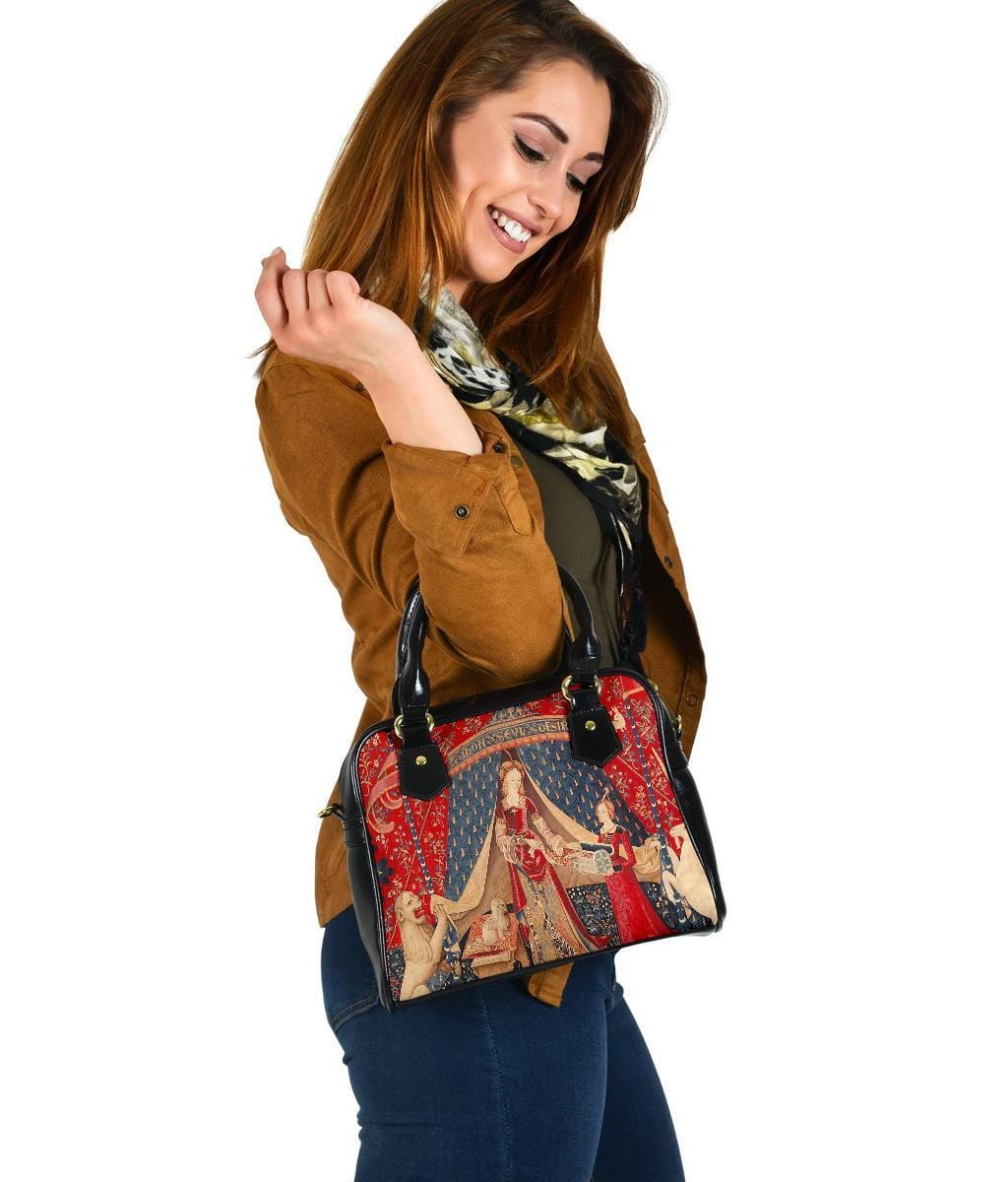 smiling woman looking down at her new The Lady & the Unicorn medieval tapestry artwork printed on a vegan leather women's handbag