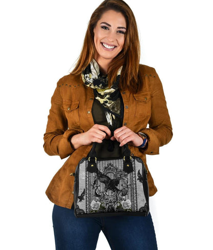 woman smiling and holding the Raven Gothic grey and black handbag
