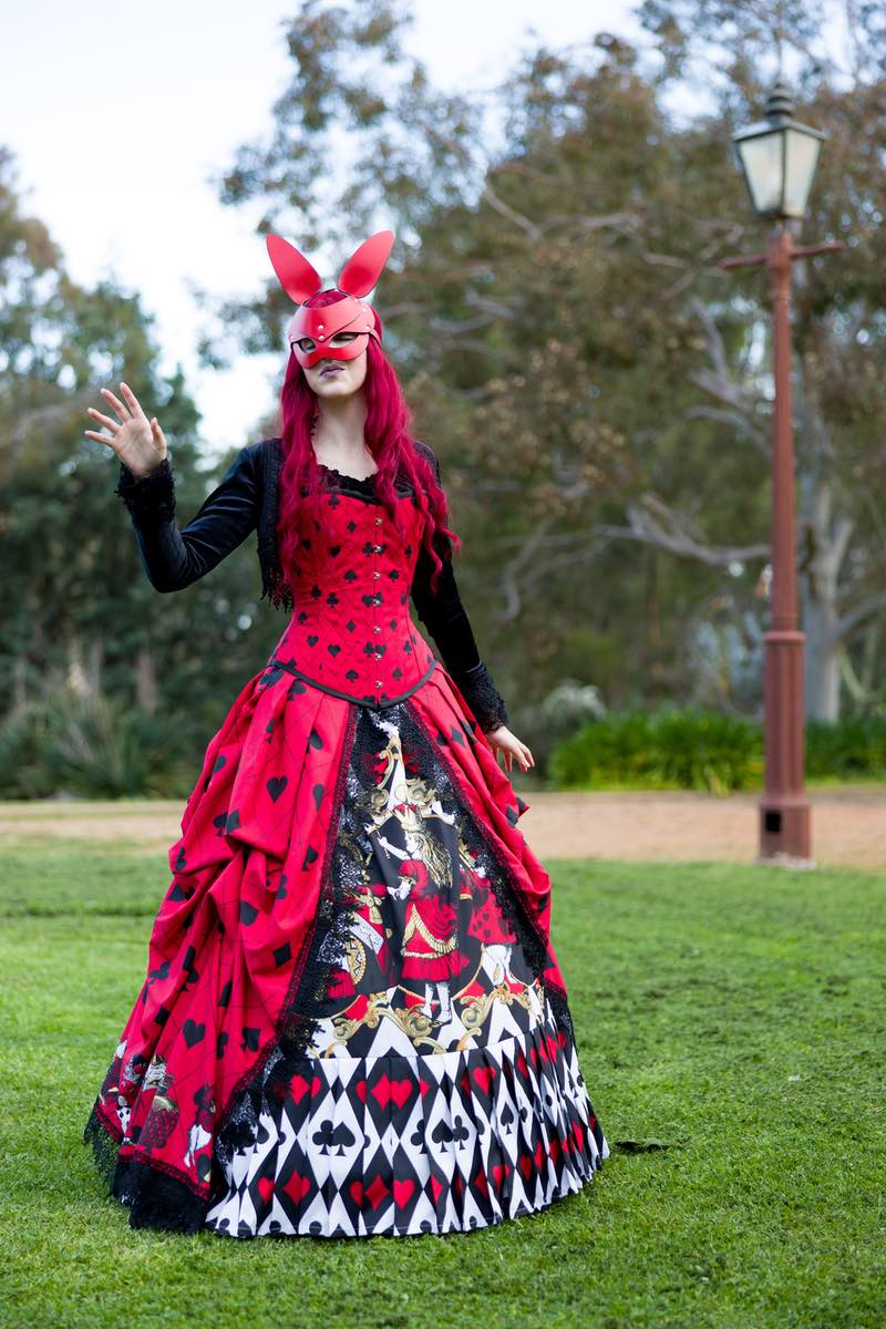 showing the cute Alice in Wonderland characters in gold red black and white on the red black and white Alice in Wonderland Queen of Hearts victorian corset gown wedding dress made in Australia