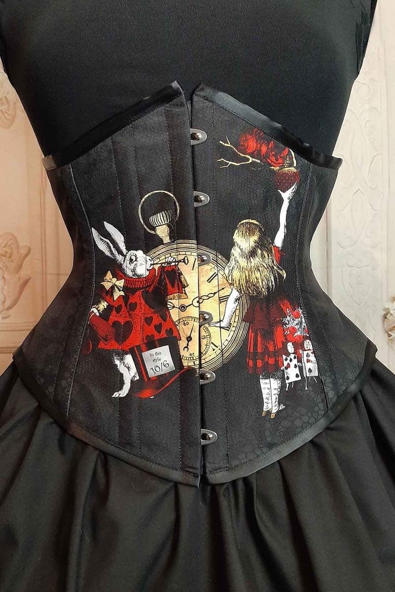 close up on the front of the Alice in Wonderland red gold black under bust corset showing the White rabbit & Alice characters