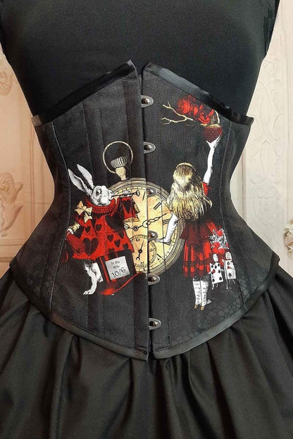 close up on the front of the Alice in Wonderland red gold black under bust corset showing the White rabbit & Alice characters