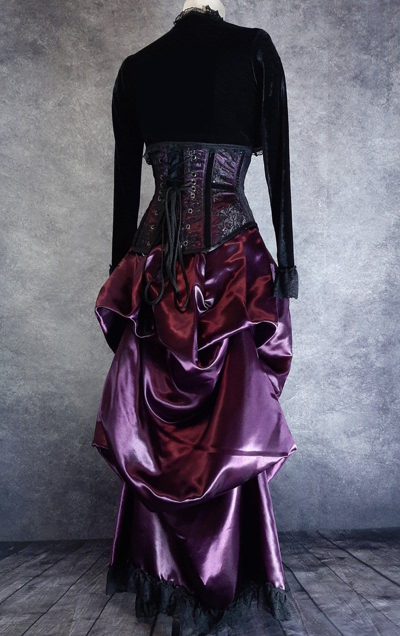 full length back view of the Amethyst Beauty Victorian Bustle Skirt and matching steel boned under bust corset set made from amethyst satin, shown on a dressmaker's form