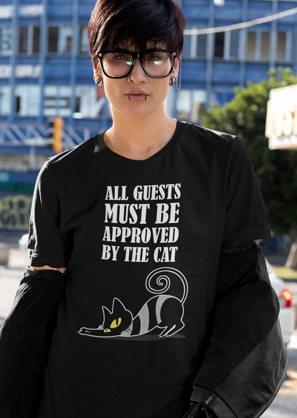 cat lover's meme tshirt featuing a meme phrase all guests must be approved by the cat in white lettering with a cute naughty black cat image