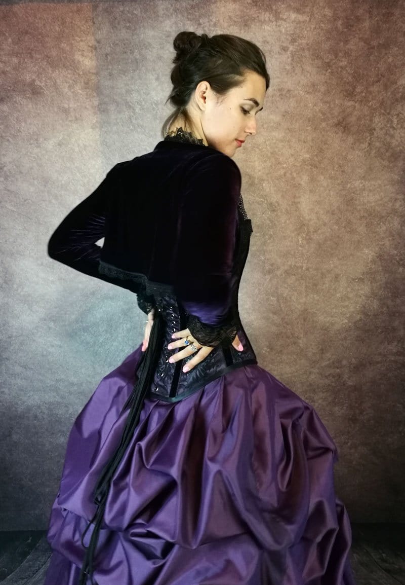 model with hands on back of her waist wearing a Gallery Serpentine purple corset