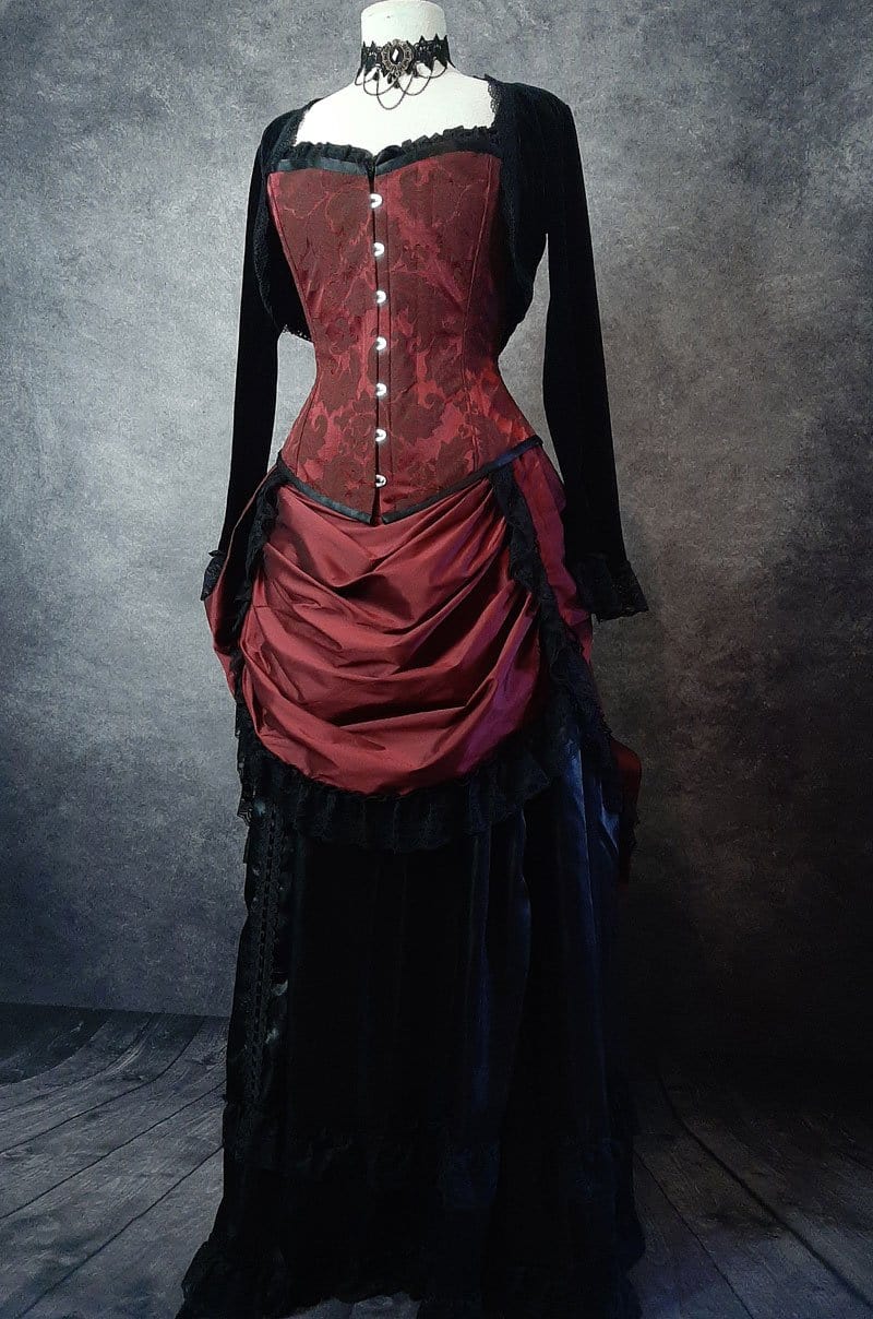 front view of the over bust corset in garnet brocade, steel boned, worn with a victorian style bustle skirt