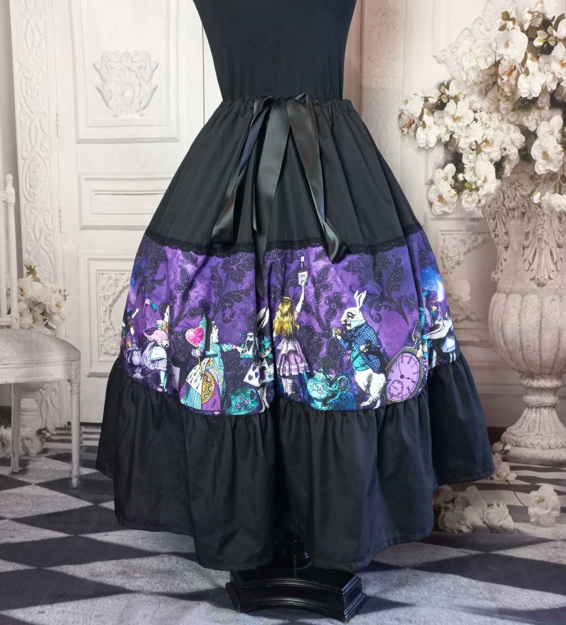 dark purple damask print background overlaid with colourful characters of Alice in Wonderland on a tea length gothic skirt for Mad Hatter Tea Parties