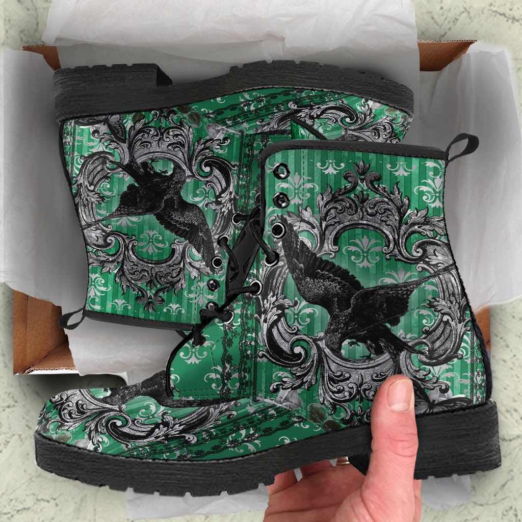 unboxing experience of the gothic raven in green background on pair of vegan leather boots
