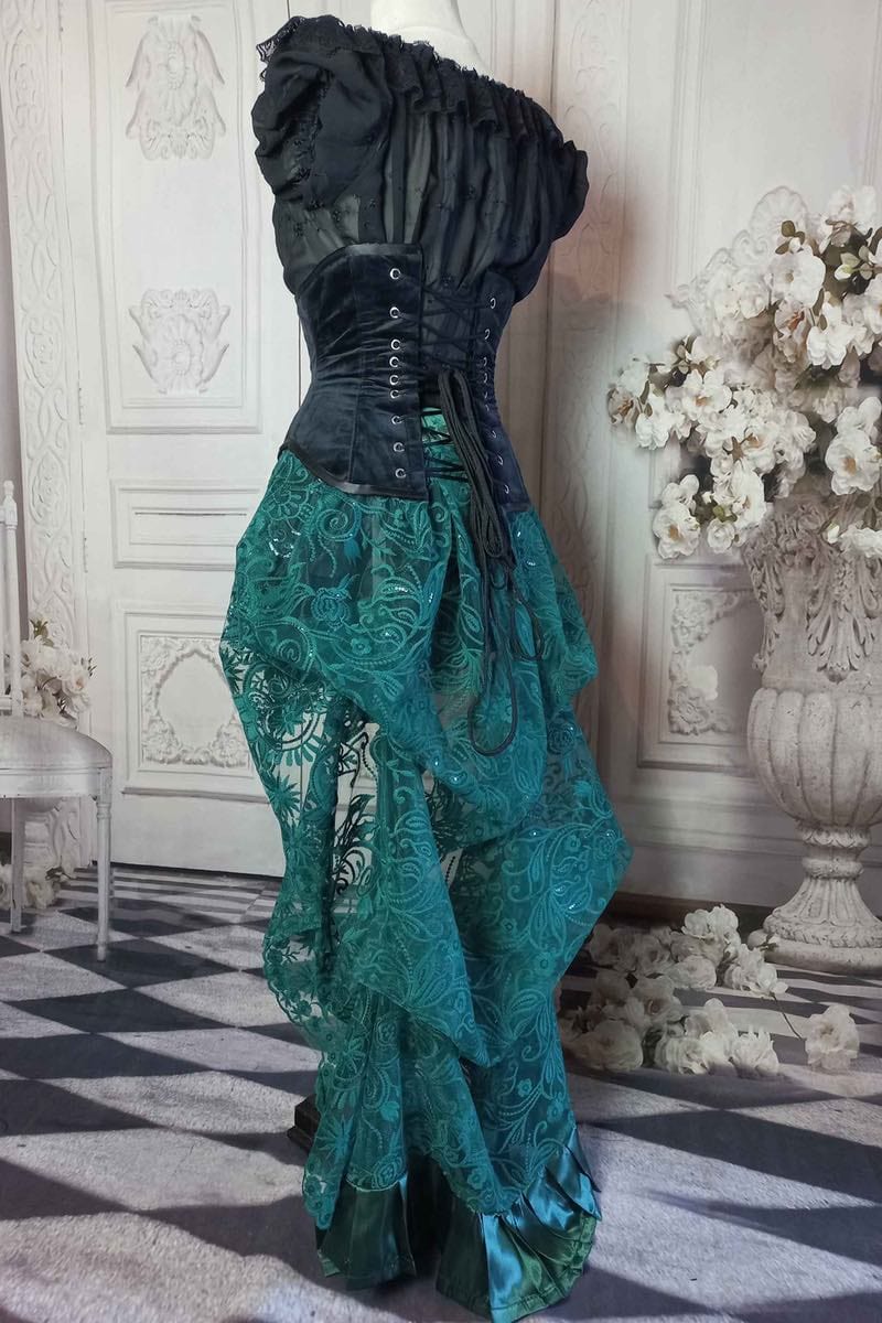 side view of the draping on the green lace victorian bustle skirt worn with a black velvet under bust corset from Gallery Serpentine