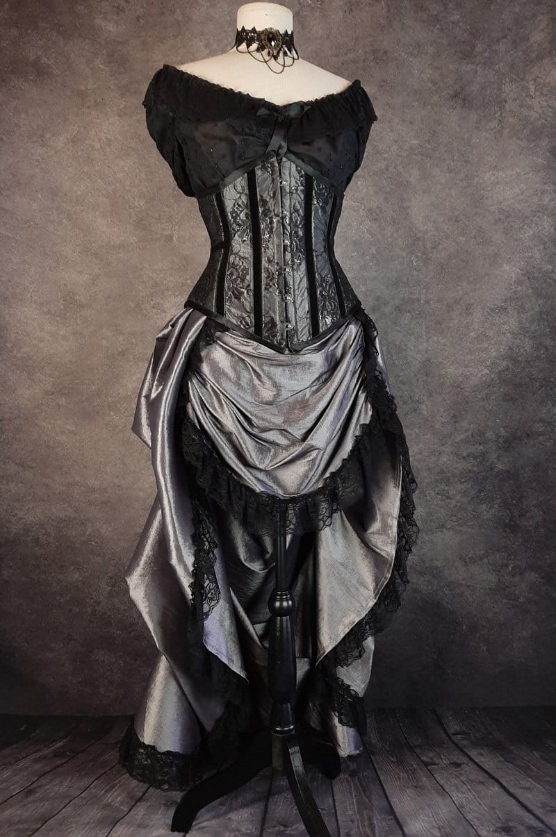 full length view from the front of the Australian made under bust tight lacing corset in a dark silver taffeta overlaid with delicate black lace and trimmed with black velvet ribbon down the corset bone channels
