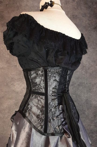 side back view focussing on the black velvet ribbon at the waist in the Australian made under bust tight lacing corset in a dark silver taffeta overlaid with delicate black lace and trimmed with black velvet ribbon down the corset bone channels