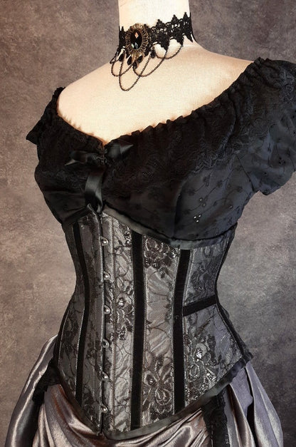 Australian made under bust tight lacing corset in a dark silver taffeta overlaid with delicate black lace and trimmed with black velvet ribbon down the corset bone channels