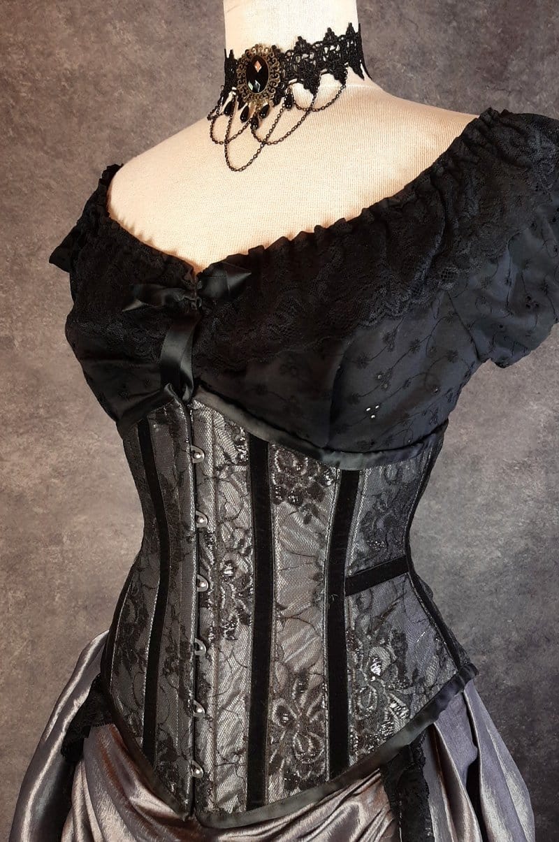 side front view of the corset in the dark shot silver taffeta victorian style bustle skirt with matching black lace covered australian made steel boned corset shown on a mannequin