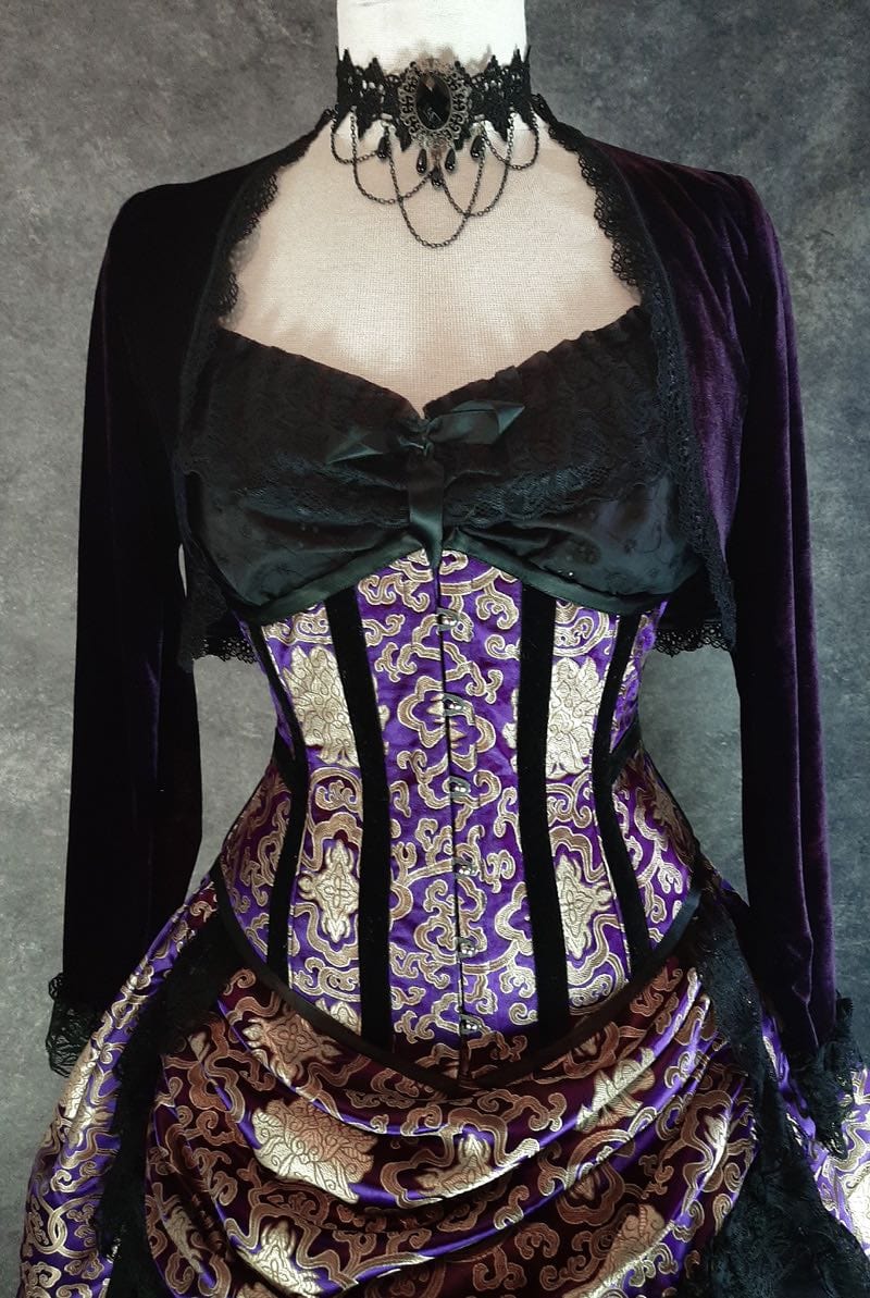 front view of the purple stretch velvet bolero shrug worn here with a chemise in black and a purple and gold corset and skirt