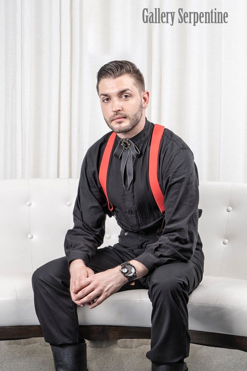 model seated wearing the Tombstone trousers, red button on suspender braces and gothic western ribbon bow tie