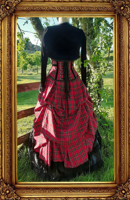 back view of the victorian punk corset ball gown in red stewart tartan fabric in an outdoor setting