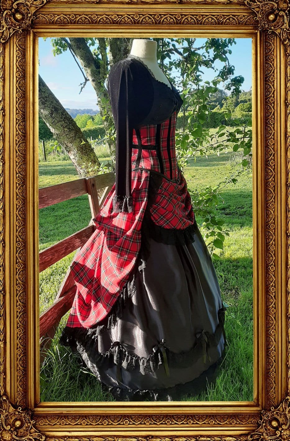 side view of the victorian punk corset ball gown in red stewart tartan fabric in an outdoor setting 