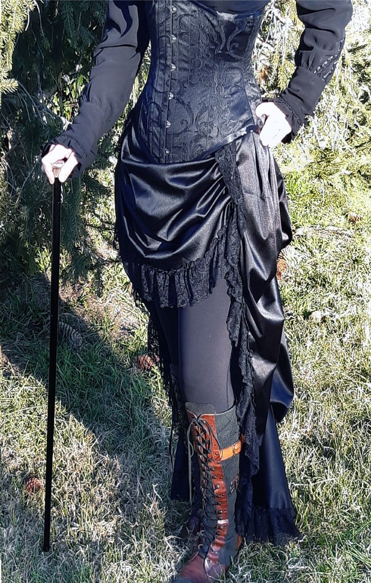 alternate side front view of the gothic victorian black sateen lace trimmed high low bustle skirt with adjustable waist sizing made in Australia for Gallery Serpentine